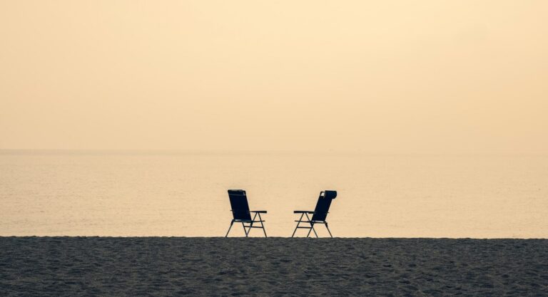 Two empty chairs on a Florida beach at sunrise